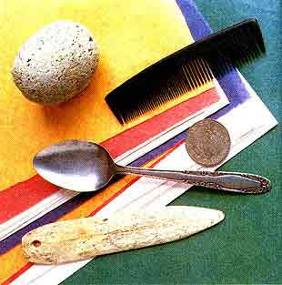 Imagen de piedras, un peine, una cuchara y una moneda