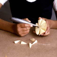 Imagen de una persona haciendo grabados en un pedazo de manzana