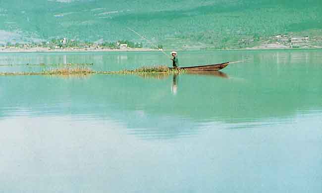 En esta imagen se ve un hombre que va en una balsa sobre el lago de Ptzcuaro.